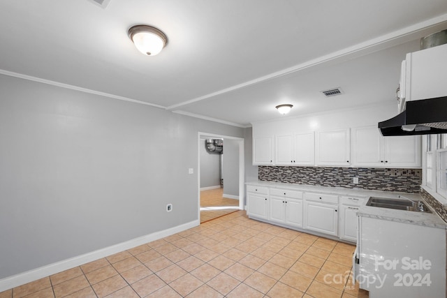 kitchen with backsplash, crown molding, exhaust hood, white cabinets, and light tile patterned flooring