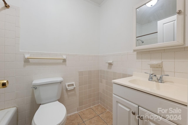 bathroom with tile patterned floors, ornamental molding, vanity, tile walls, and toilet