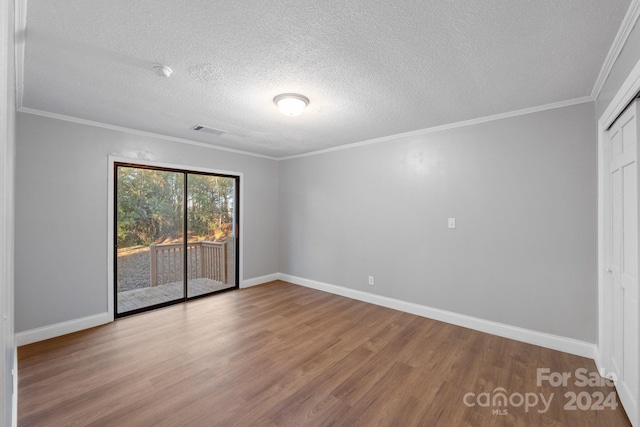 unfurnished room with wood-type flooring, a textured ceiling, and ornamental molding