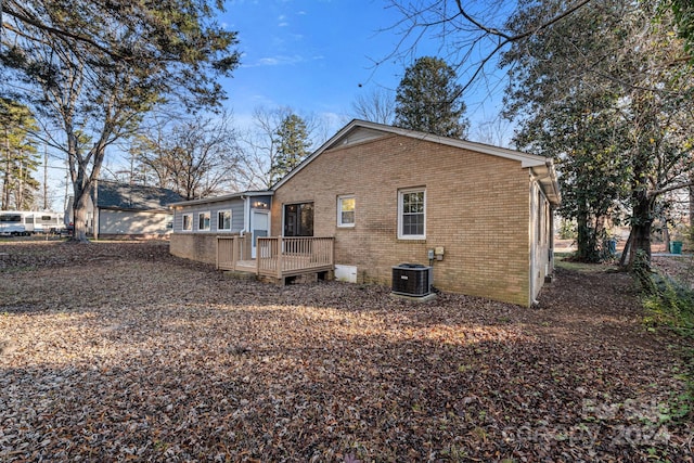 back of house featuring central AC unit and a deck