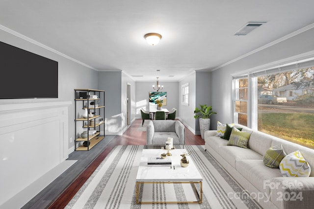 living room with a notable chandelier, dark hardwood / wood-style flooring, and ornamental molding