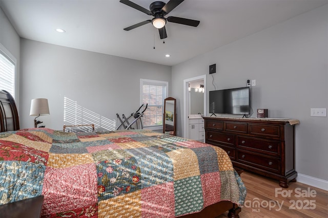 bedroom with ceiling fan, light wood-type flooring, and multiple windows