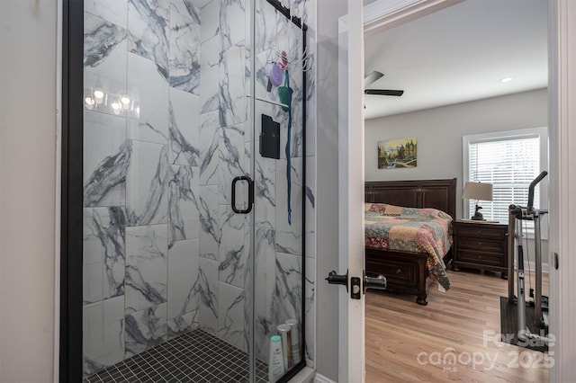 bathroom with hardwood / wood-style flooring, ceiling fan, and a shower with door