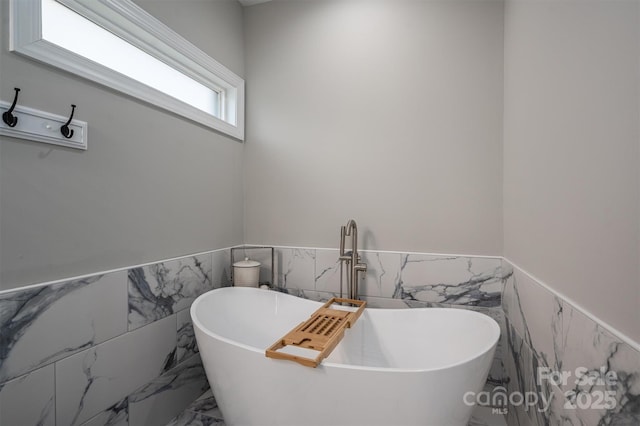 bathroom with a bath and tile walls