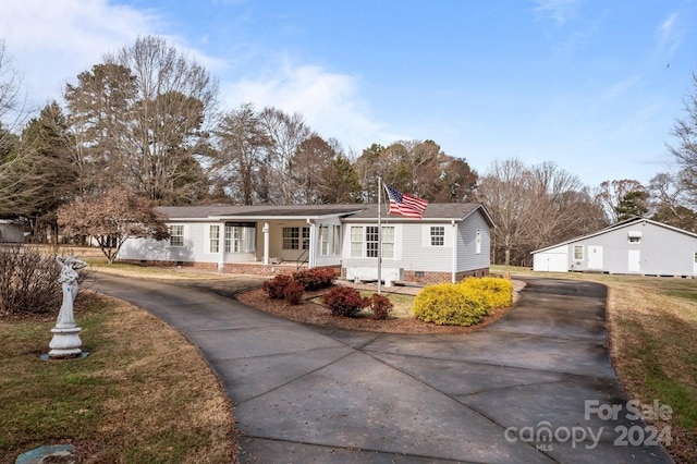 view of front of house featuring a porch and an outdoor structure