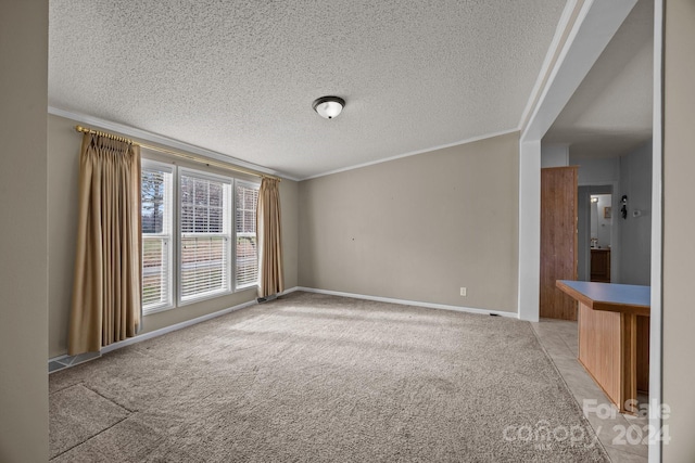 unfurnished room featuring a textured ceiling and ornamental molding