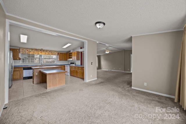 kitchen with white appliances, a textured ceiling, light colored carpet, ceiling fan, and a center island