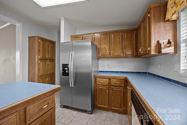 kitchen with stainless steel appliances, crown molding, a textured ceiling, vaulted ceiling, and light tile patterned floors