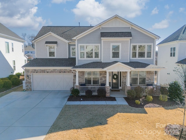 view of front of house with covered porch, a garage, and a front lawn