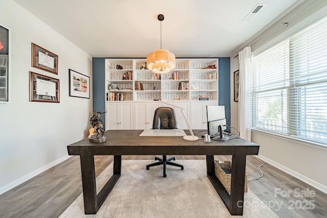 office space featuring hardwood / wood-style flooring and built in features