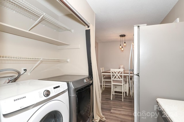 washroom with washer and dryer, dark wood-type flooring, and a textured ceiling