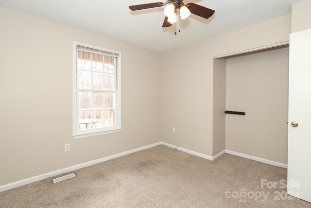 carpeted spare room featuring ceiling fan