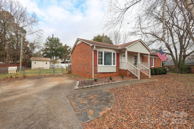 view of front of house featuring crawl space, driveway, fence, and brick siding