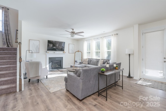 living room with ceiling fan and light hardwood / wood-style flooring