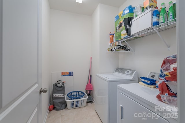 laundry area featuring light tile patterned floors and washing machine and clothes dryer