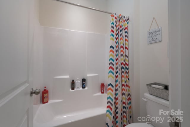 bathroom featuring shower / tub combo with curtain and toilet