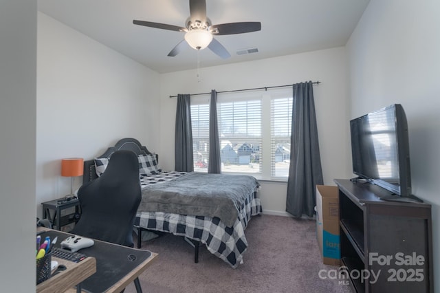 carpeted bedroom featuring multiple windows and ceiling fan