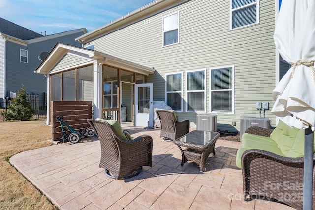 rear view of property featuring a patio area, a sunroom, and central AC unit