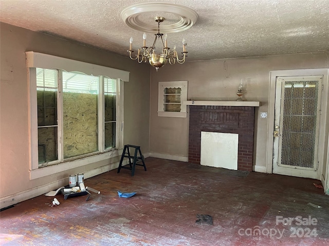 unfurnished living room with a fireplace, a textured ceiling, and an inviting chandelier