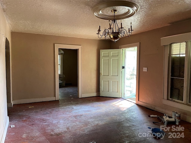 foyer entrance featuring a textured ceiling and an inviting chandelier