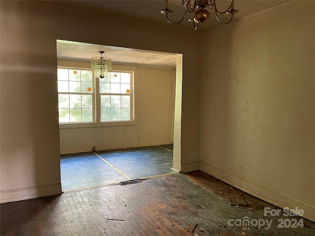 unfurnished dining area with dark hardwood / wood-style floors and a notable chandelier