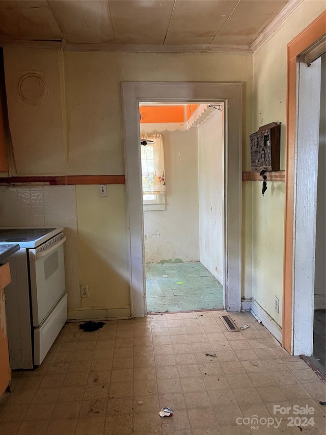 kitchen featuring ornamental molding and white stove