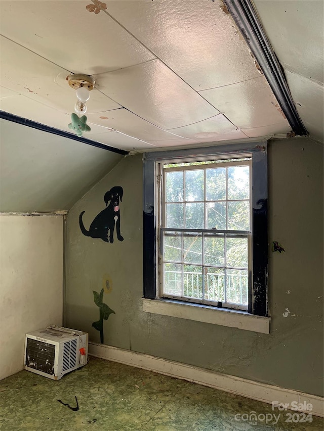 bonus room featuring a wall mounted AC and vaulted ceiling