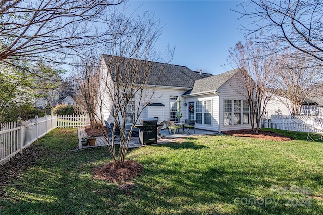 back of house with a yard and a patio