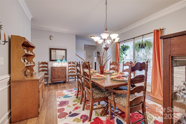 dining room featuring a notable chandelier, crown molding, and light hardwood / wood-style flooring