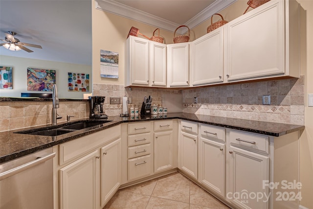 kitchen with backsplash, stainless steel dishwasher, dark stone countertops, and sink