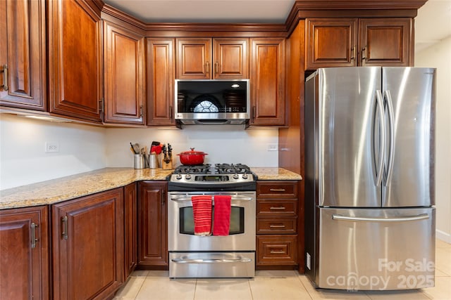 kitchen featuring light stone counters, light tile patterned flooring, and stainless steel appliances