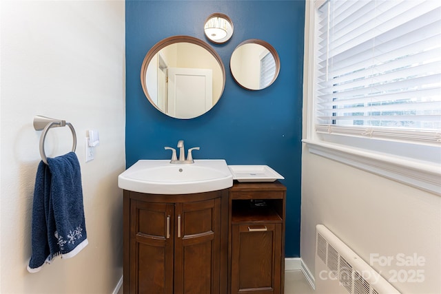 bathroom featuring radiator heating unit, vanity, and a baseboard heating unit