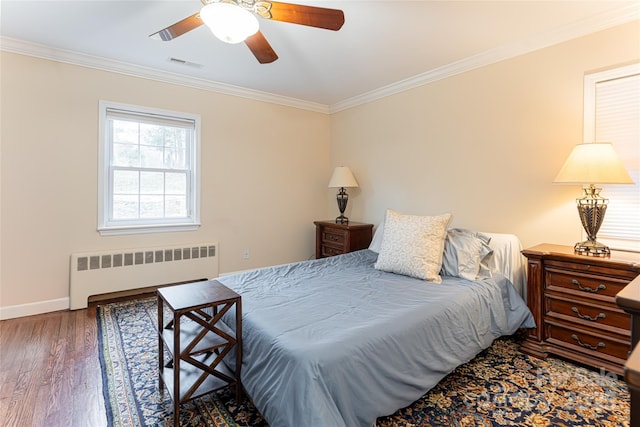 bedroom with radiator heating unit, dark hardwood / wood-style floors, ceiling fan, and crown molding