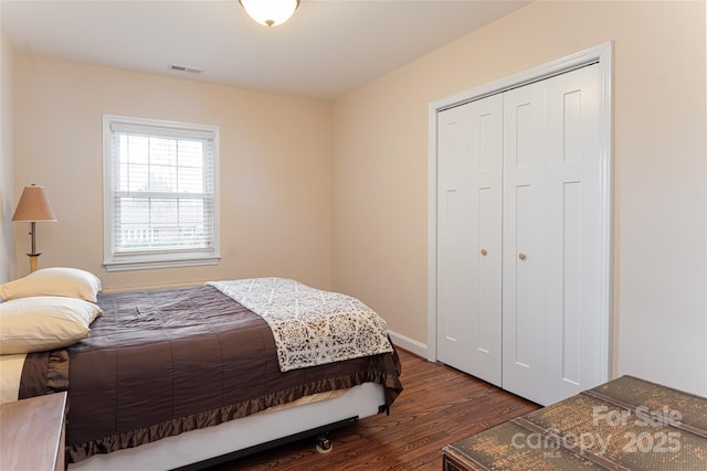 bedroom with dark hardwood / wood-style floors and a closet