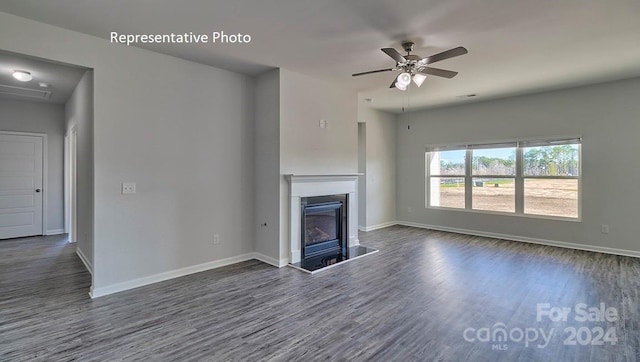 unfurnished living room featuring ceiling fan and dark hardwood / wood-style flooring