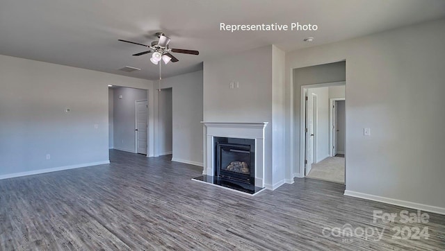 unfurnished living room with ceiling fan and dark wood-type flooring