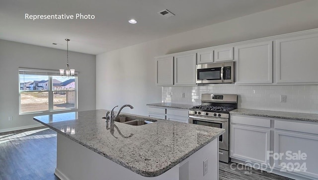 kitchen with a center island with sink, white cabinets, stainless steel appliances, and sink