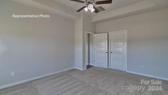 unfurnished bedroom with ceiling fan, light carpet, and a closet