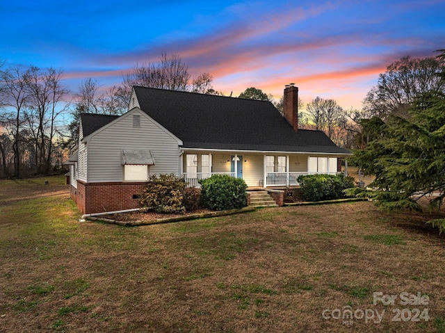 view of front of house with a yard and a porch