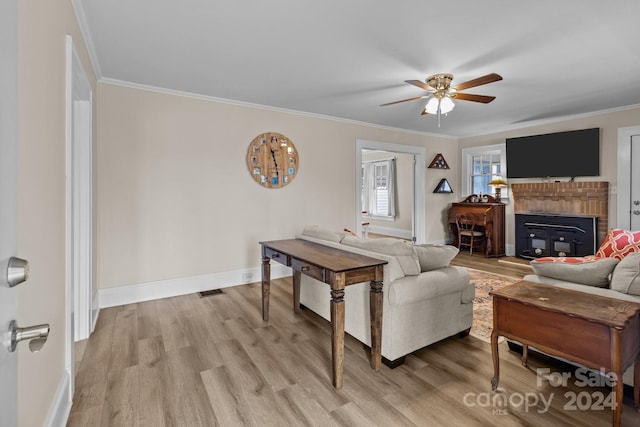 living room with light hardwood / wood-style floors, ceiling fan, and ornamental molding