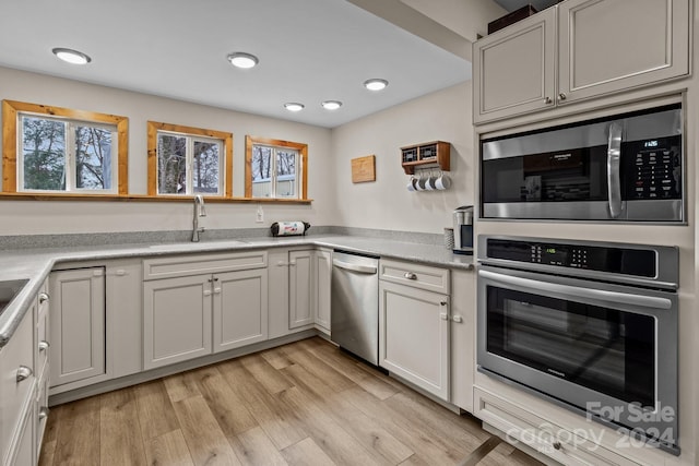 kitchen with plenty of natural light, light hardwood / wood-style floors, sink, and stainless steel appliances