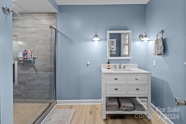 bathroom with vanity, wood-type flooring, and walk in shower