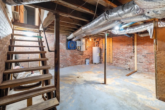 basement with brick wall, electric panel, and water heater