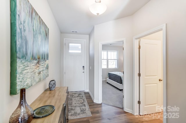 foyer with dark wood-style floors, visible vents, and baseboards