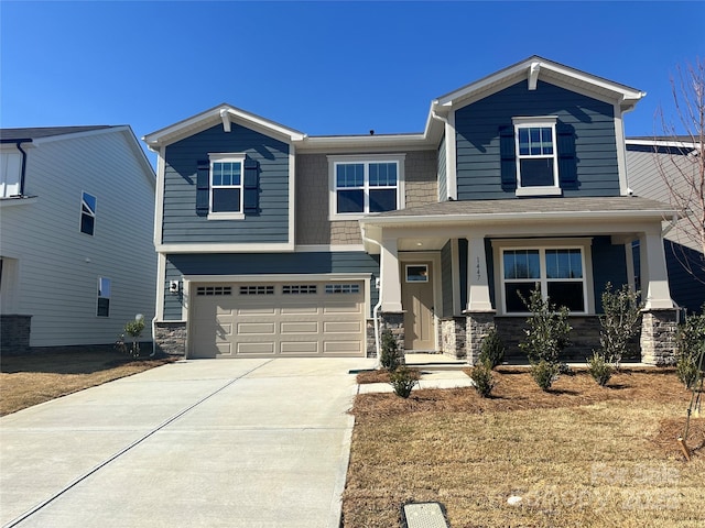 craftsman inspired home with stone siding, covered porch, an attached garage, and concrete driveway