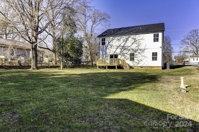 rear view of property with a yard and a deck