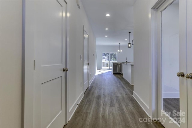 corridor featuring a chandelier and dark hardwood / wood-style floors