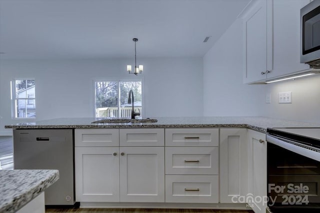 kitchen featuring appliances with stainless steel finishes, light stone counters, sink, a notable chandelier, and white cabinets