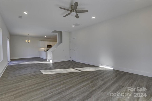 unfurnished living room with dark hardwood / wood-style flooring, ceiling fan, and sink