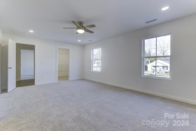 unfurnished room featuring light colored carpet and ceiling fan